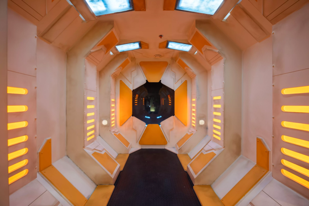 Décor futuriste inspiré d’un vaisseau spatial de science-fiction, avec couloir technologique, éclairages intégrés et ambiance immersive digne d’un film spatial.