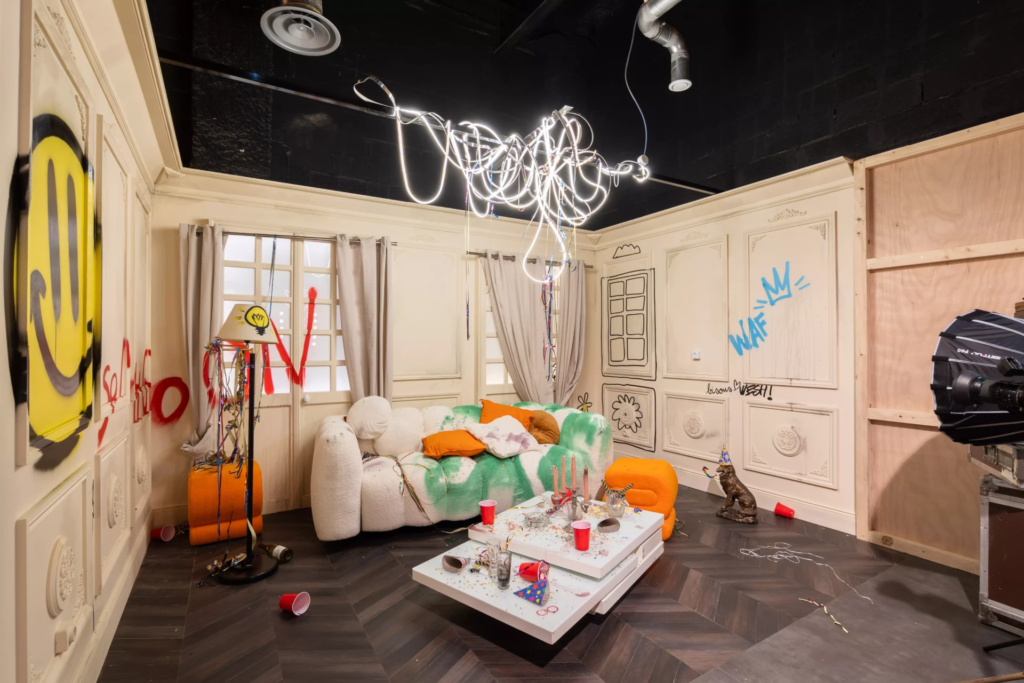 Décor de salon artistique après fête, avec mobilier design, accessoires festifs, graffitis contemporains et ambiance décalée inspirée des soirées entre amis.