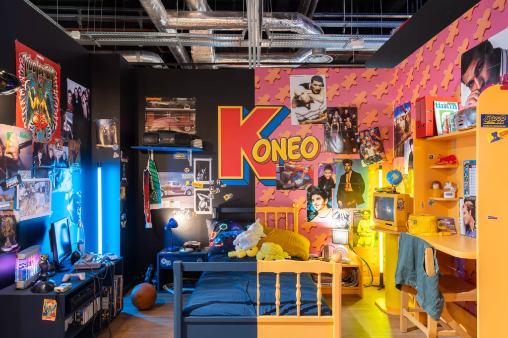 Décor immersif inspiré d’une chambre d’adolescent des années 2000, avec posters cultes, jeux vidéo rétro, télévision vintage, ordinateur d’époque et ambiance nostalgique Y2K.