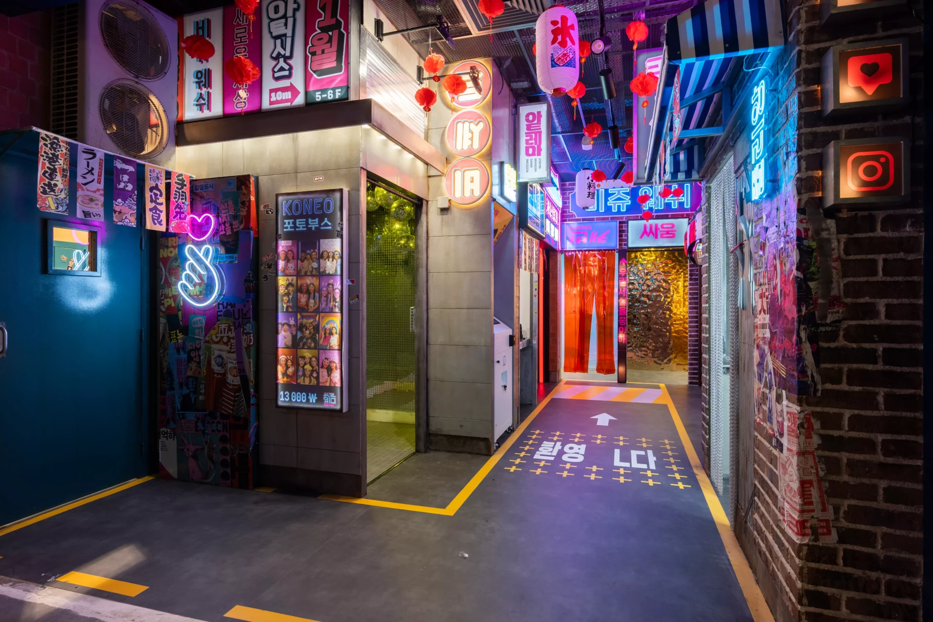 Décor urbain inspiré des rues de Séoul, avec photobooth coréen, enseignes lumineuses, affiches colorées et atmosphère immersive digne d’un drama coréen.