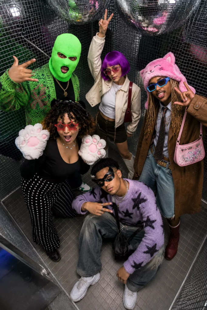 Groupe d’amis dans le photobooth Disco de KONEO Studio à Paris avec accessoires fun et boules à facettes.