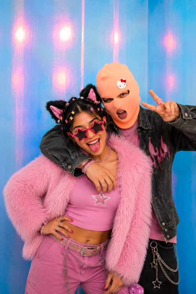 Couple posant dans le photobooth Irisé de KONEO Studio à Paris avec accessoires colorés.