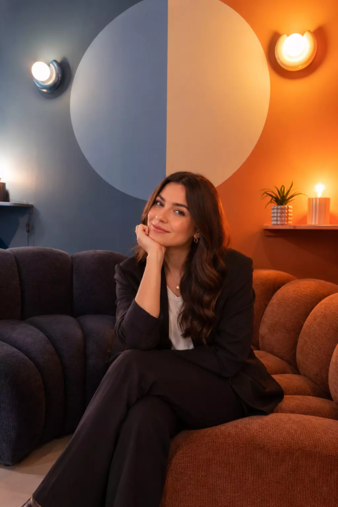 Photo d'une jeune femme en train de poser dans le décor immersif "Canapé" chez KONEO Studio, visiblement pour une phoot Linkedin