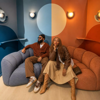 Photo d'un couple de trentenaires en train de poser dans le décor immersif Canapé de KONEO Studio