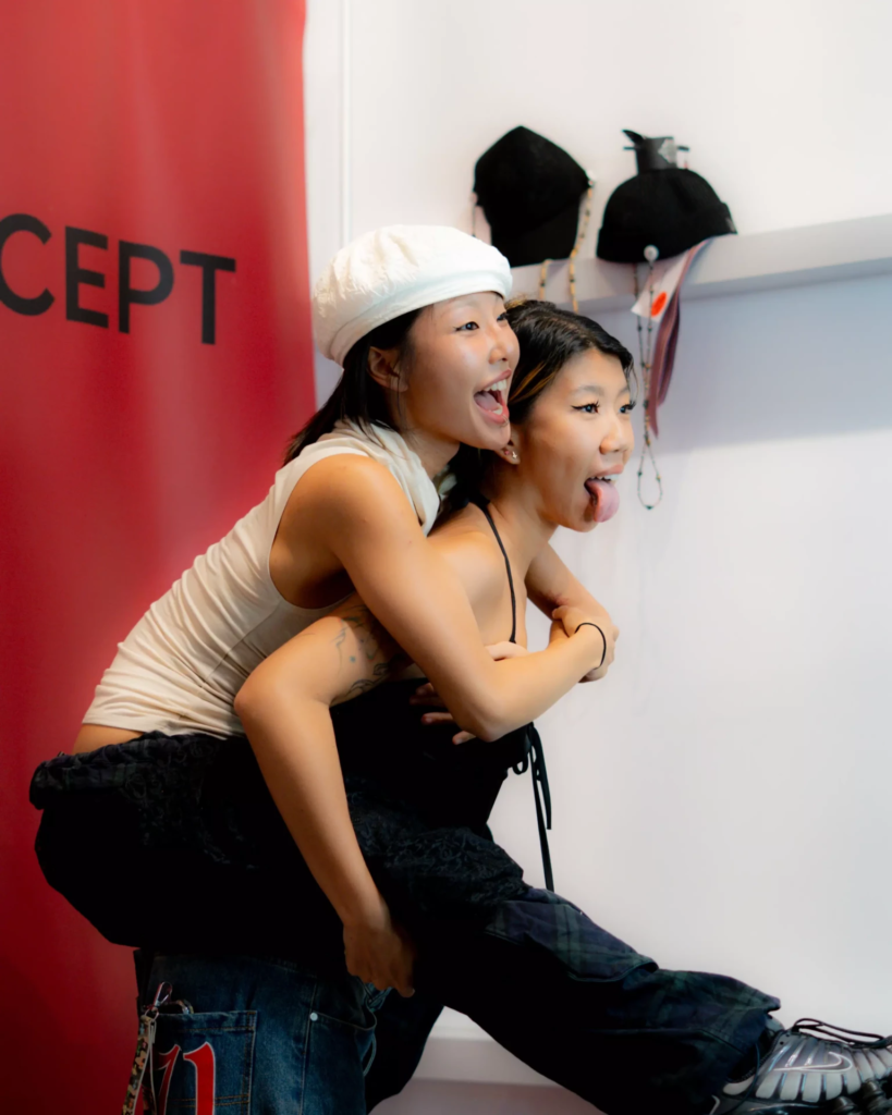 Texte alternatif : Deux amies prennent une pose complice et décalée devant le photomaton, l’une portée sur le dos de l’autre. Souriantes et pleines d’énergie, elles jouent face à l’objectif dans une ambiance spontanée et ludique.